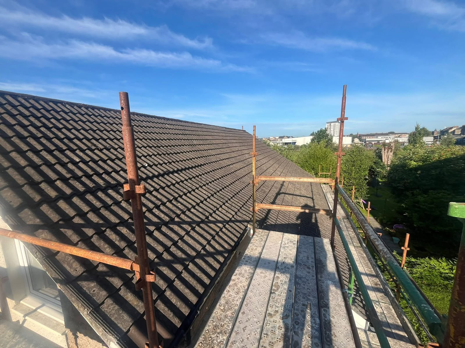 Roofing Glasgow: long run of newly laid roof tiles seen from the scaffold