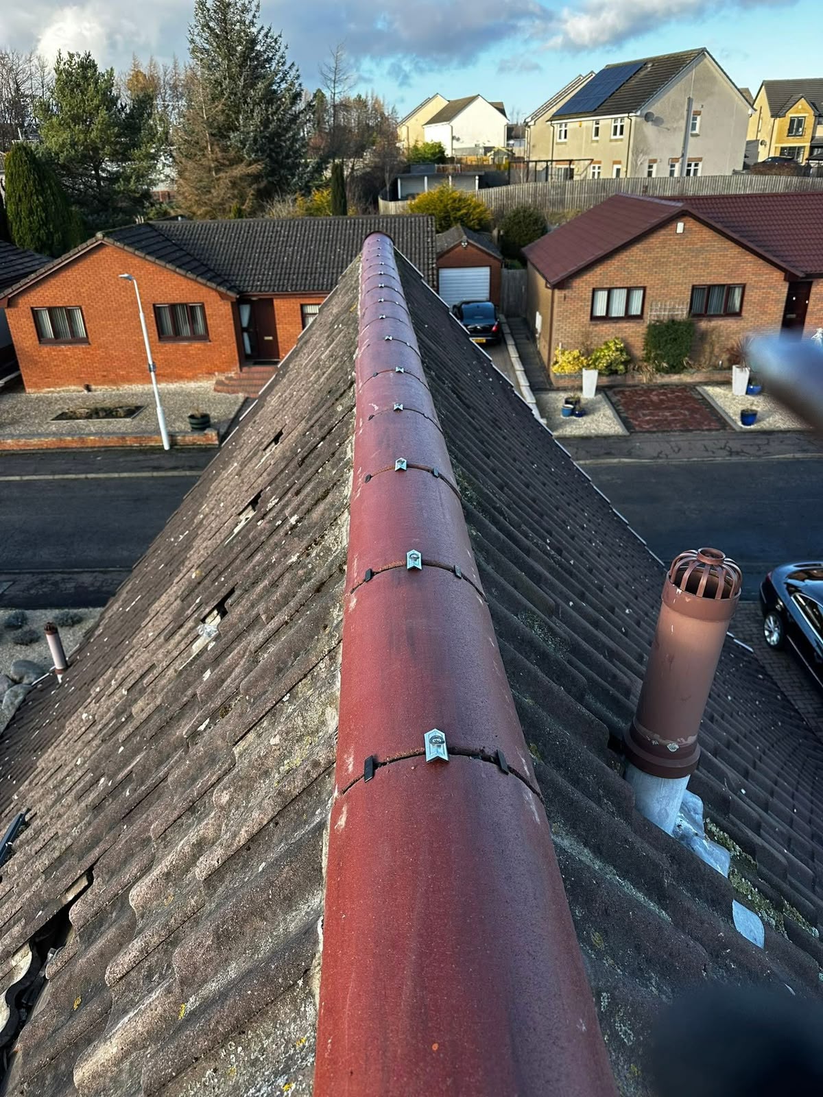 Roofing Glasgow: red ridge tiles secured with mechanical dry fix clips